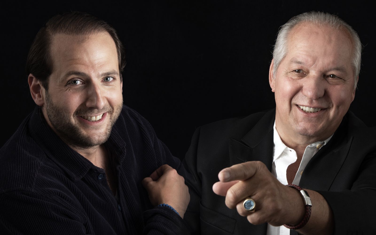 Aufnahme der beiden Auktionatoren auf dunklem Hintergrund