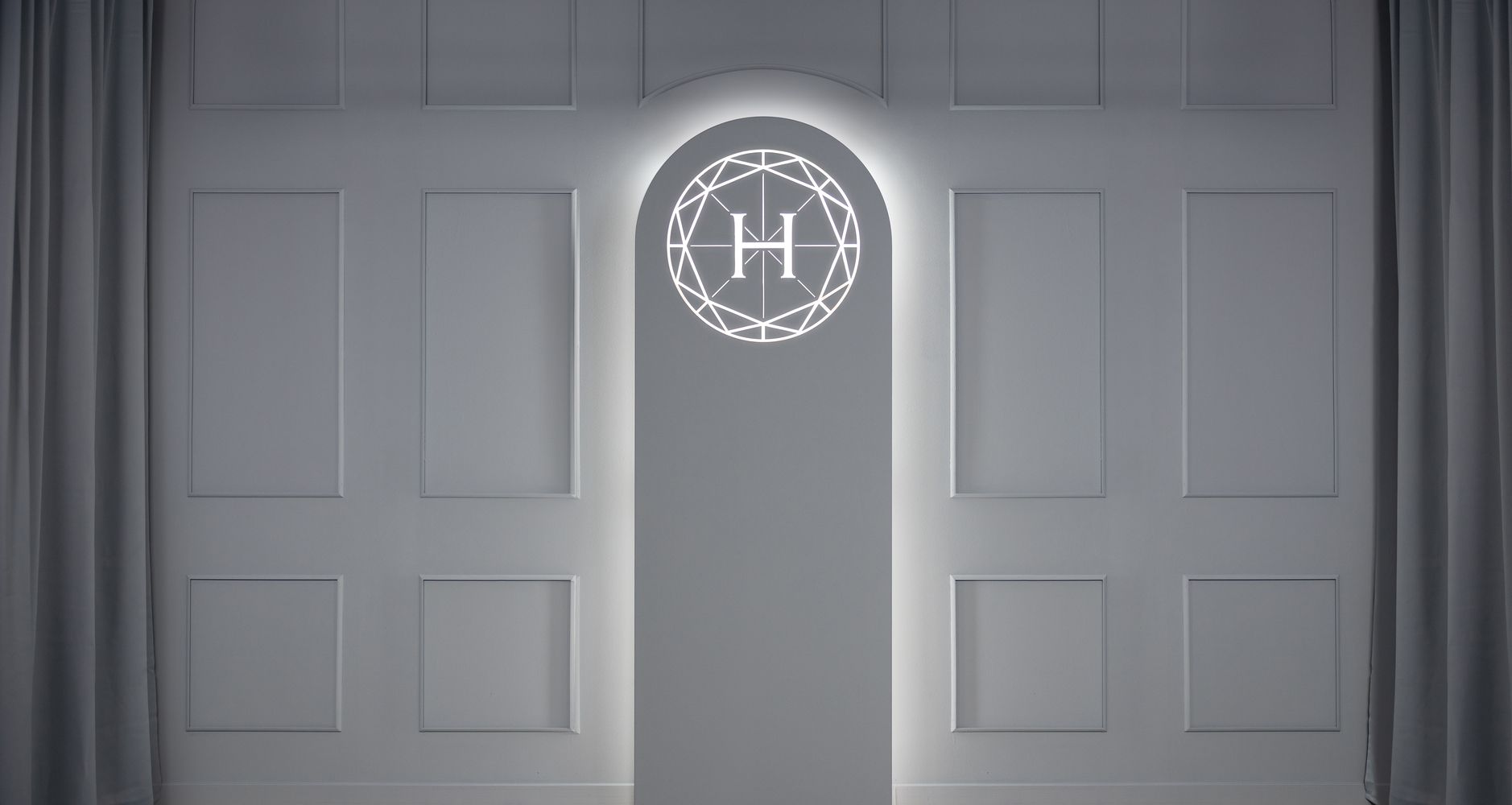 Unser beleuchtetes Logo auf einem strukturierten weißen Hintergrund